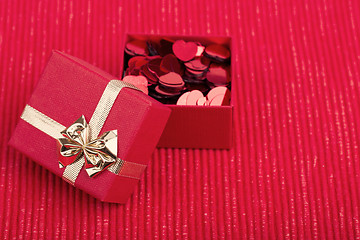 Image showing Red hearts confetti on fabric background