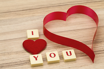 Image showing valentine's paper hearts on a wooden background and tex i love you