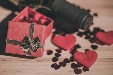 Image showing bottle of vine, red hearts and small present a retro style