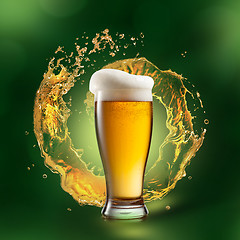 Image showing Beer in glass with splash on green background