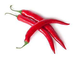 Image showing Three juicy red ripe sharp intersecting chili peppers