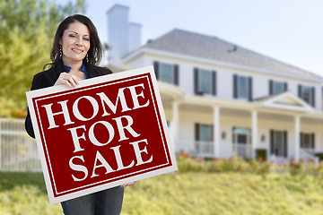 Image showing Woman Holding Home For Sale Sign in Front of House