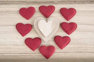 Image showing valentine's fabric and wooden hearts on a wooden background