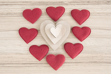 Image showing valentine's fabric and wooden hearts on a wooden background