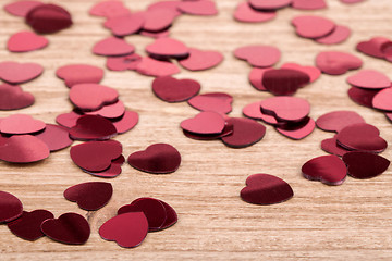 Image showing Red hearts confetti on wooden background