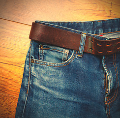 Image showing Aged blue jeans with a leather belt 