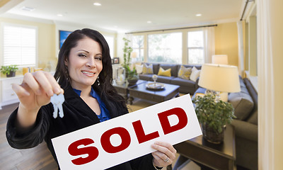 Image showing Hispanic Woman with Keys and Sold Sign in Living Room