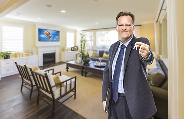 Image showing Male Real Estate Agent Holding Keys in Beautiful Living Room