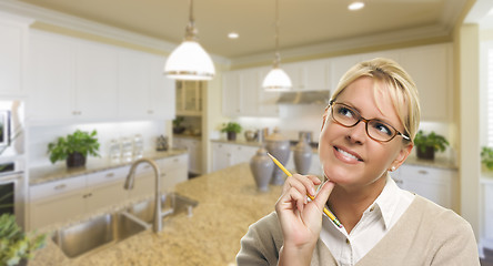 Image showing Daydreaming Woman with Pencil Inside Beautiful Kitchen