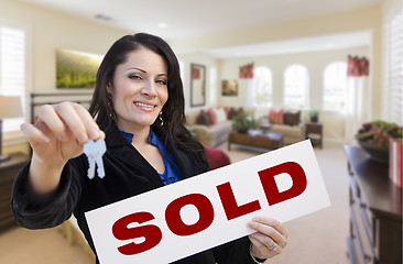 Image showing Hispanic Woman with Keys and Sold Sign in Living Room