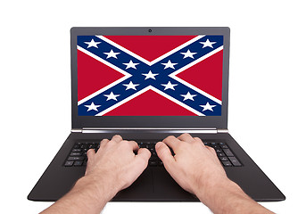 Image showing Man working on laptop, confederate flag