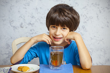 Image showing boy with tea and biscuits