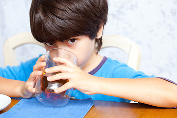 Image showing child drinks morning beverage