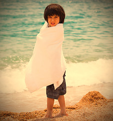 Image showing boy wrapped in a white towel on the beach