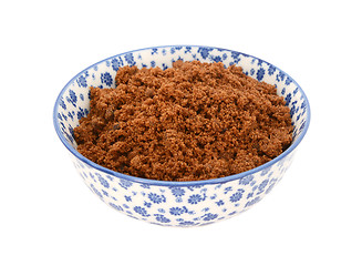 Image showing Dark brown soft sugar in a blue and white china bowl