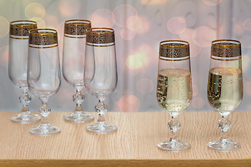 Image showing Six beautiful glass wine glasses, two filled with champagne.