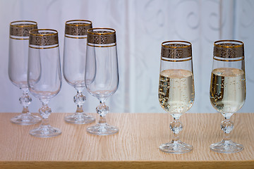 Image showing Six beautiful glass wine glasses, two filled with champagne.