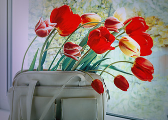 Image showing Flowers tulips and a women bag on a window window sill.