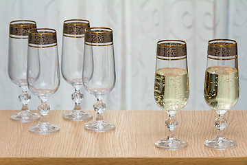 Image showing Six beautiful glass wine glasses, two filled with champagne.