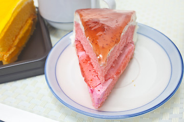 Image showing Orange Cheesecake with Strawberry cheesecake in plate on backgro