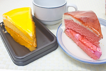 Image showing Orange Cheesecake with Strawberry cheesecake in plate on backgro