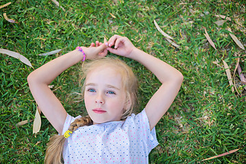 Image showing Caucasian little girl lay on grass