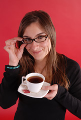 Image showing Girl smiling holding tea and glasses