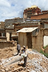 Image showing Men working with Tibetan temple in the background