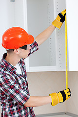 Image showing builder with yellow tape measure