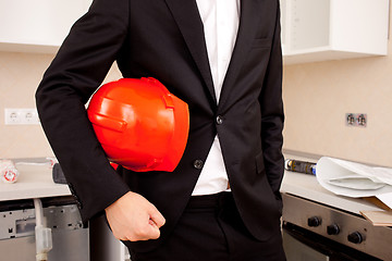 Image showing businessman holding red helmet