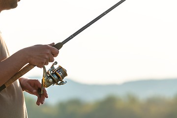 Image showing Modern clean fishing rod in hands