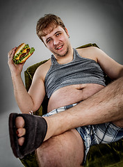 Image showing Fat man eating hamburger