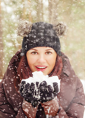 Image showing Cute young woman playing with snow  outdoors