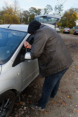 Image showing Hooligan breaking into car