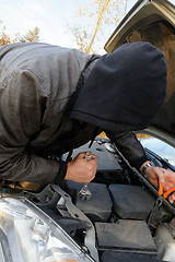 Image showing Hooligan breaking into car