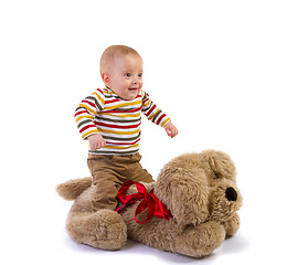 Image showing baby boy jump over plush dog