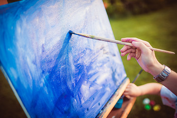 Image showing Mother and little daughter paint together