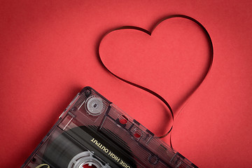 Image showing Audio cassette tape on red backgound. Film shaping heart