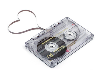 Image showing Audio cassette tape on white backgound. Film shaping heart