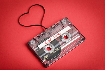 Image showing Audio cassette tape on red backgound. Film shaping heart