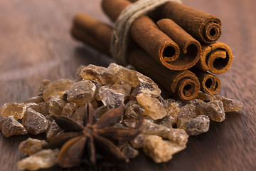 Image showing Cinnamon sticks with pure cane brown sugar on wood background