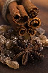 Image showing Cinnamon sticks with pure cane brown sugar on wood background