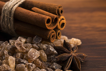 Image showing Cinnamon sticks with pure cane brown sugar on wood background