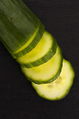 Image showing cucumber slices on on black plate