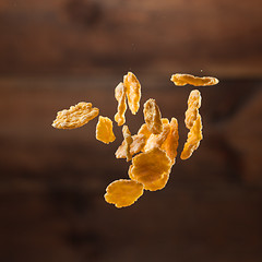 Image showing Falling corn flakes on wooden background