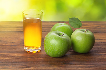Image showing Glass of apple juice and apples on wood
