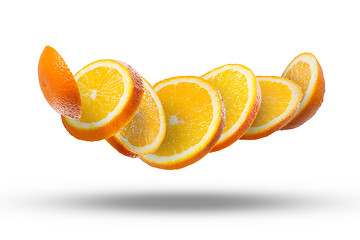 Image showing Falling slices of orange in air on white