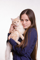 Image showing The girl is holding a red cat