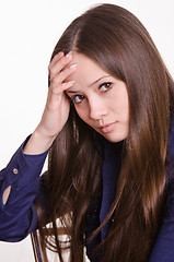 Image showing Girl with long hair holds a hand to his forehead