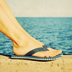 Image showing Female feet in blue flip-flops, retro image